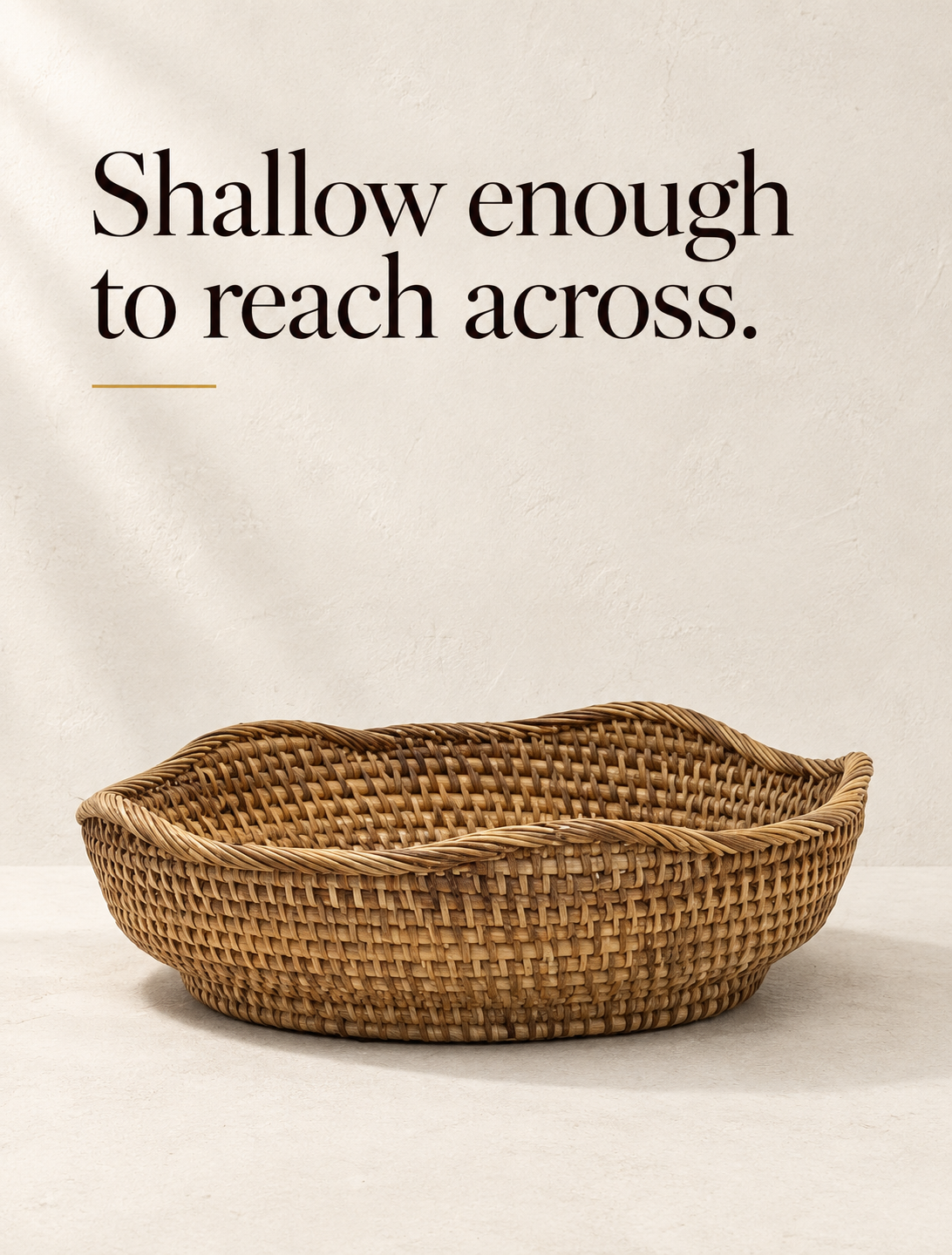 A shallow round bowl in undyed rattan, woven as one spiral from the centre out.